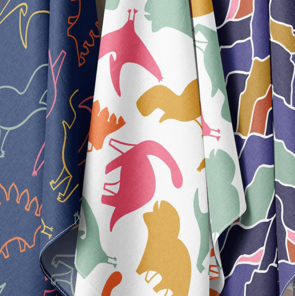 colourful dinosaur fabric collection hanging on pegs