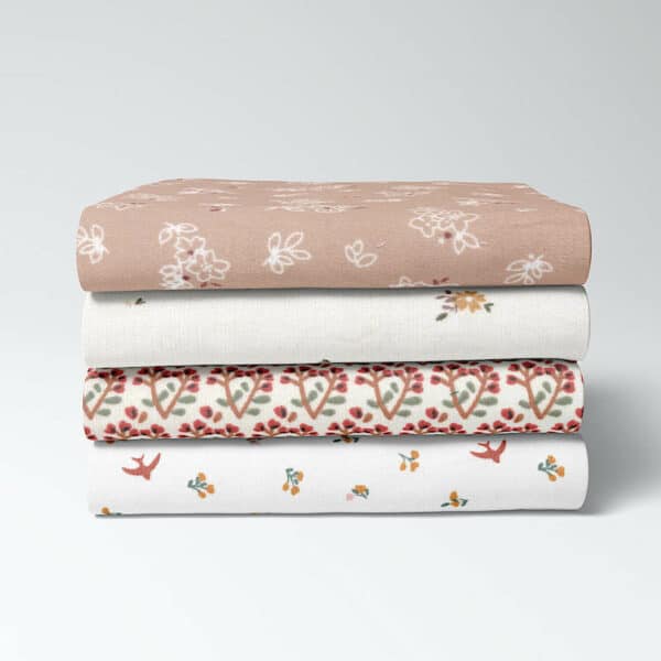 Stack of coordinating pretty printed cotton babycord fabrics Image3a